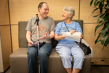 Paul Miller, left, sits with his mother, Carolyn Miller. He is regaining his independence as he copes with vision loss. Neurosurgeons at UMMC were able to remove between 80 and 90 percent of his tumor.